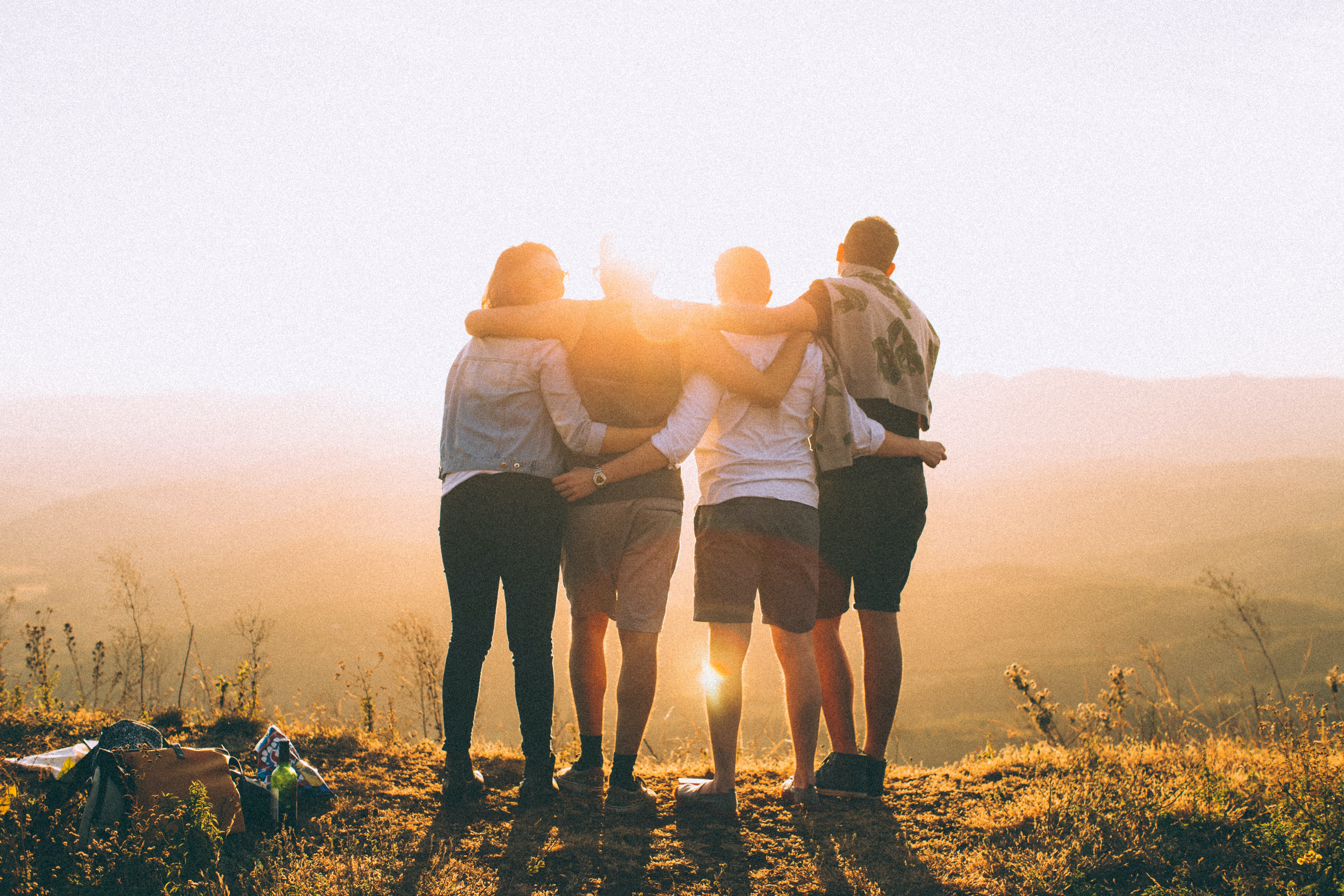 friends hugging in the forest with sunset